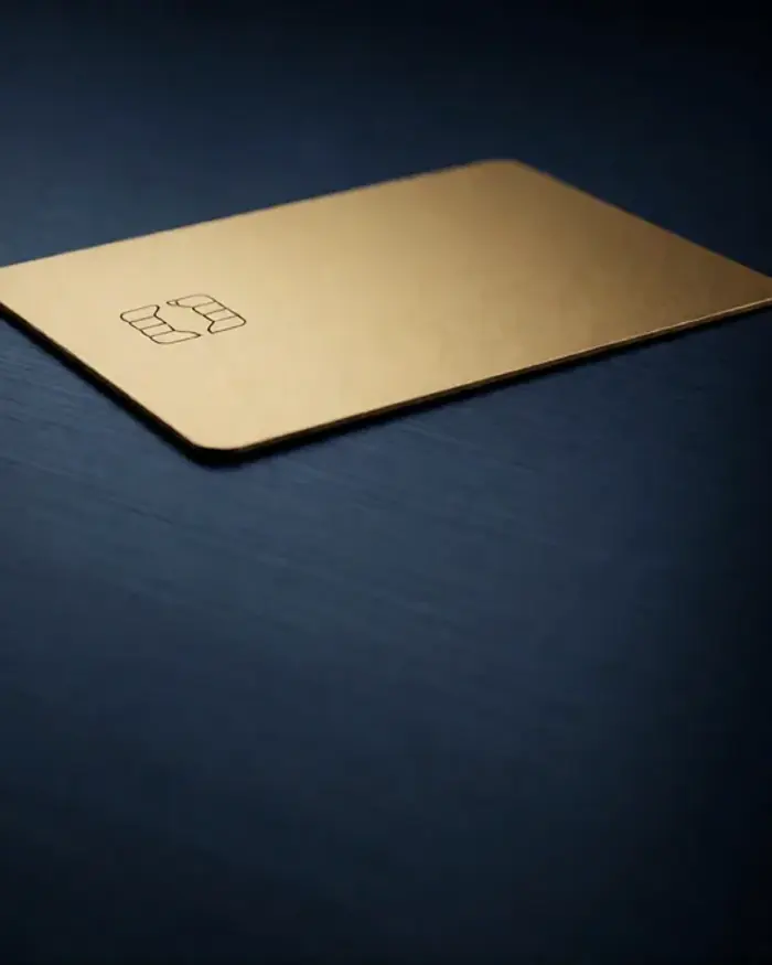 Gold credit card on a brushed navy surface